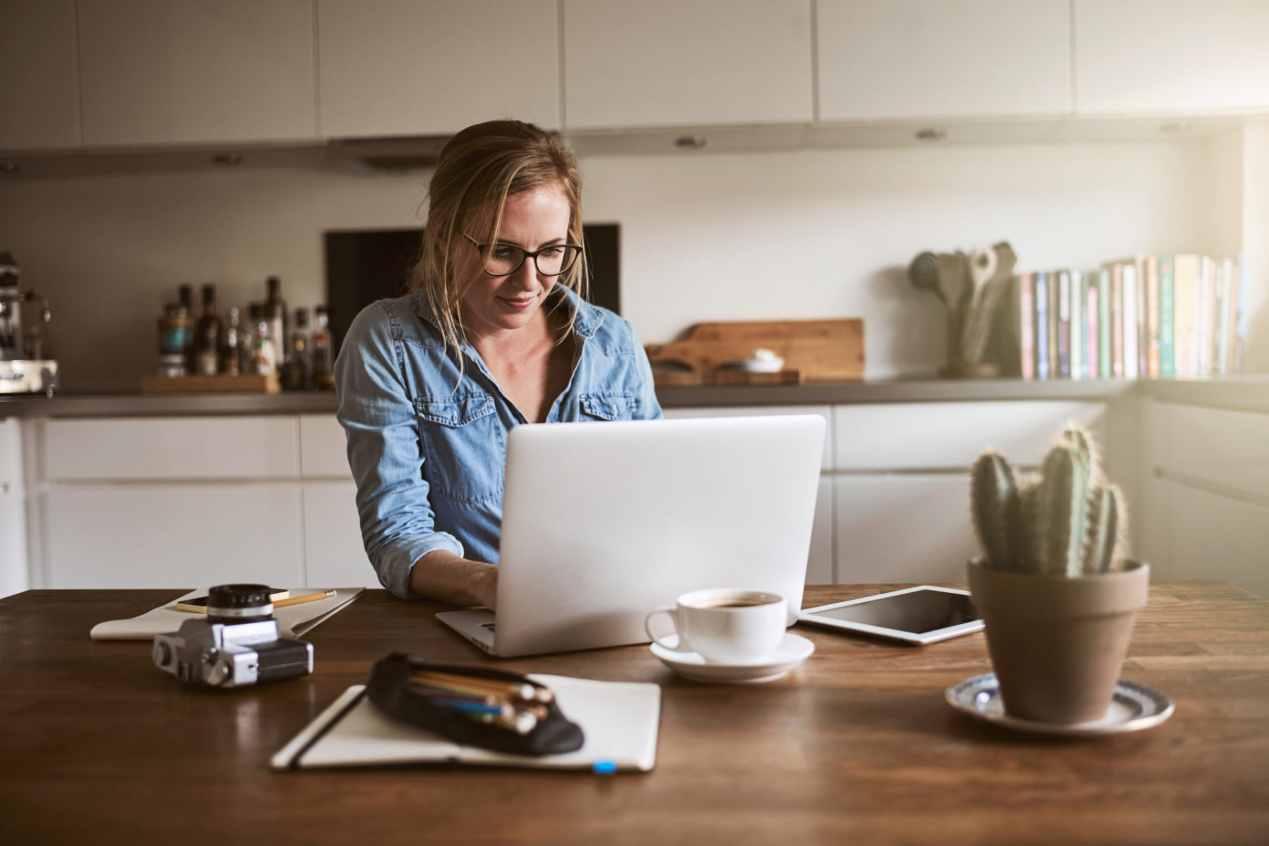 Female entrepreneur sitting in her kitchen working on a laptop Livre Si simple Bruno Savoyat Télétravail
