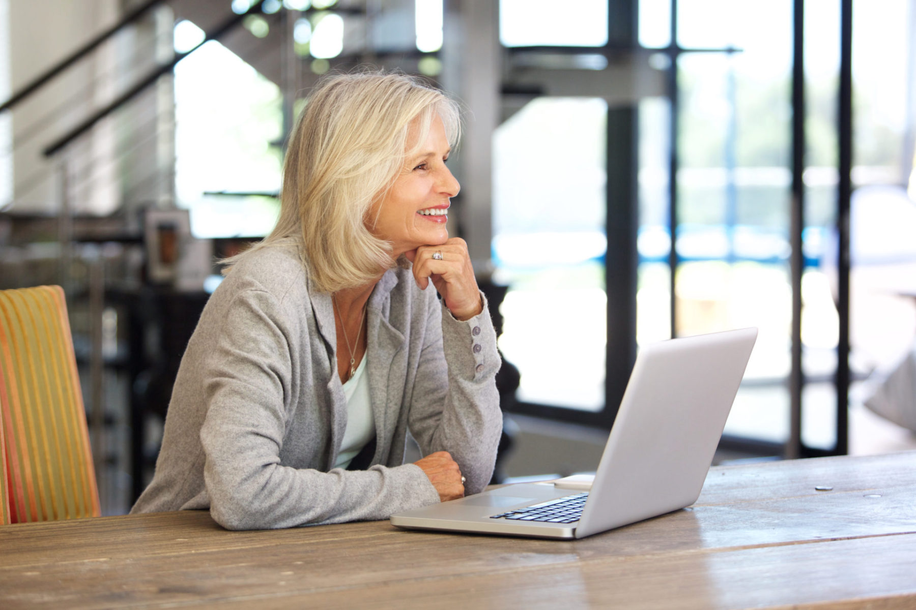 smiling older woman working laptop computer indoors Livre Si simple Bruno Savoyat Télétravail